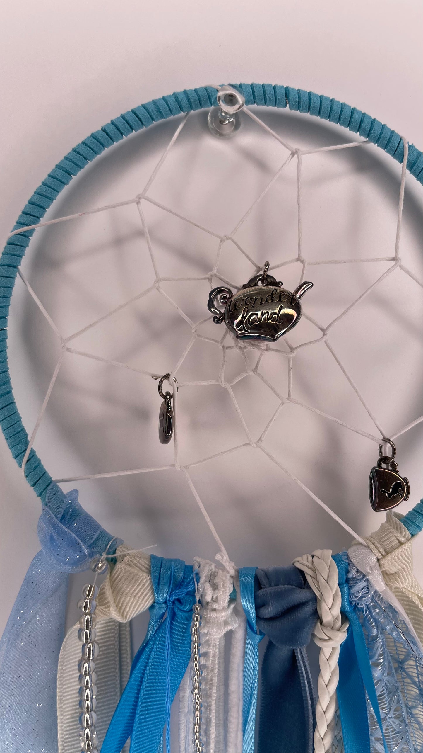 Dreamcatcher with hanging charms on a white background