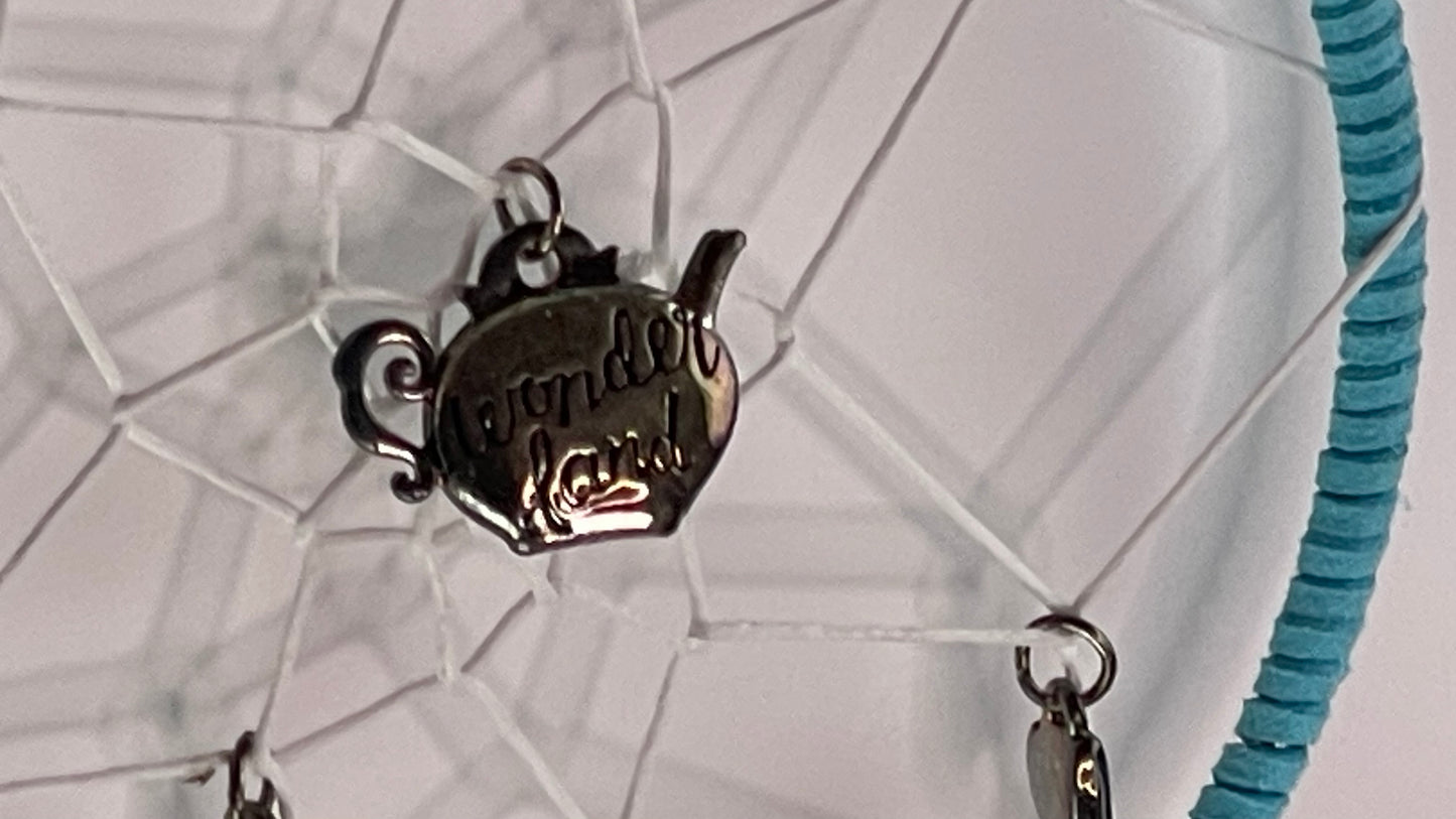 Teapot-shaped pendant with text on a white background