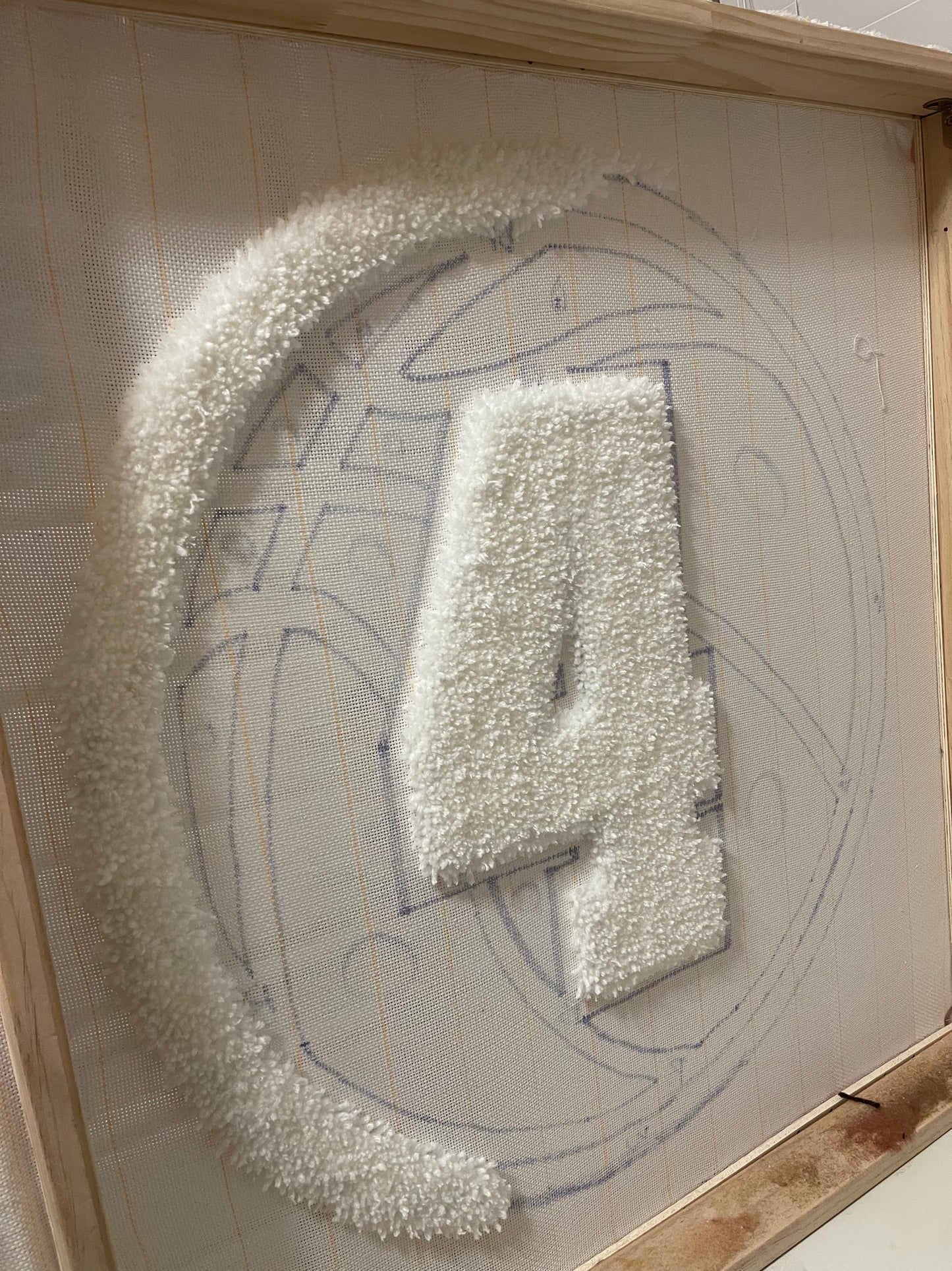 Decorative number '4' for basketball rug in progress.