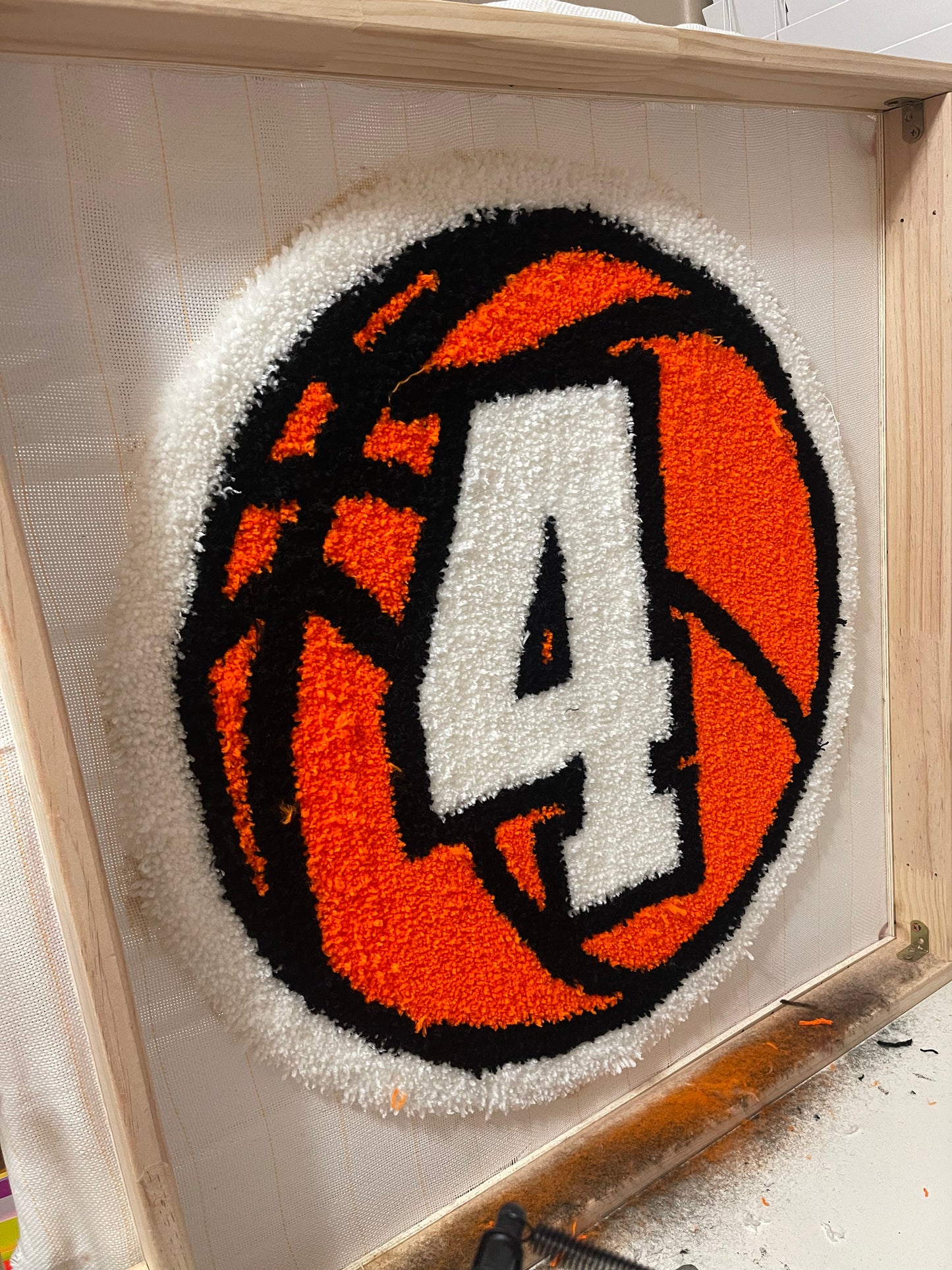 Basketball-themed rug with a large number '4' on an orange background, in progress