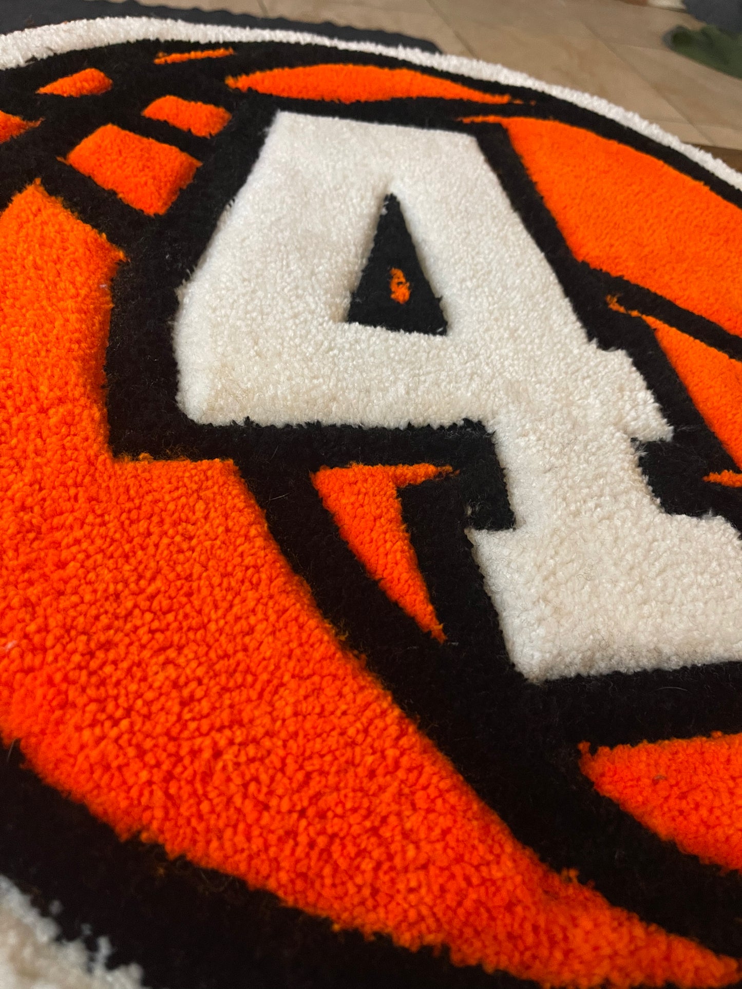 Close-up of a textured rug with a large white number '4' on an orange basketball.