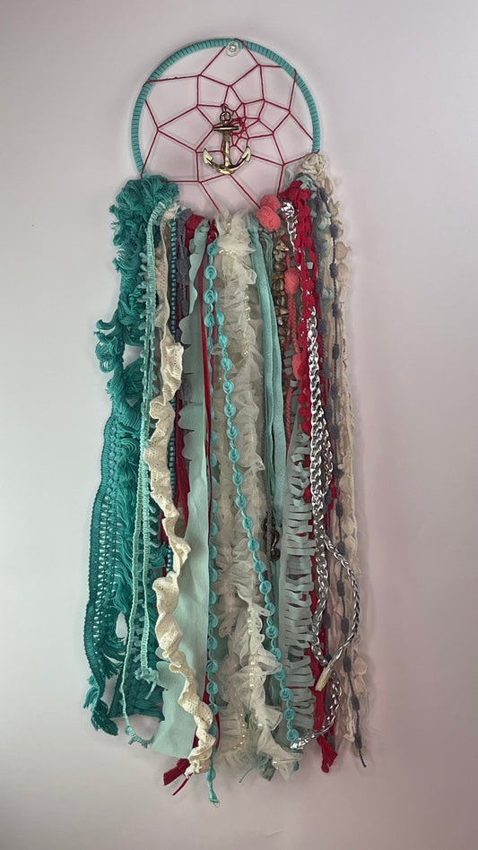 Decorative dreamcatcher with colorful ribbons on a plain background